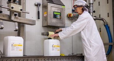 Vrouw in fabriek voor vloeibare suiker 