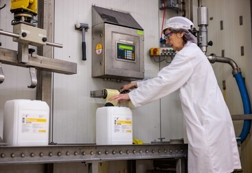 Vrouw in fabriek voor vloeibare suiker 